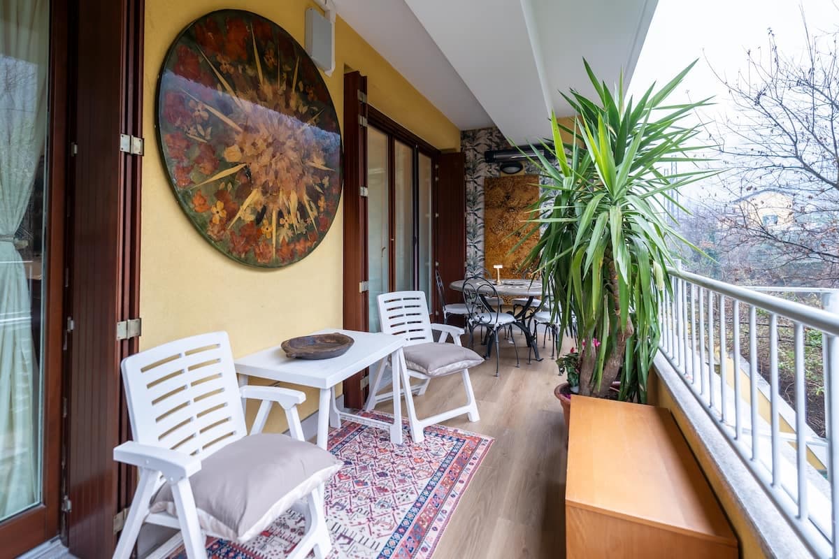 Balcone arredato con tavolo e piante