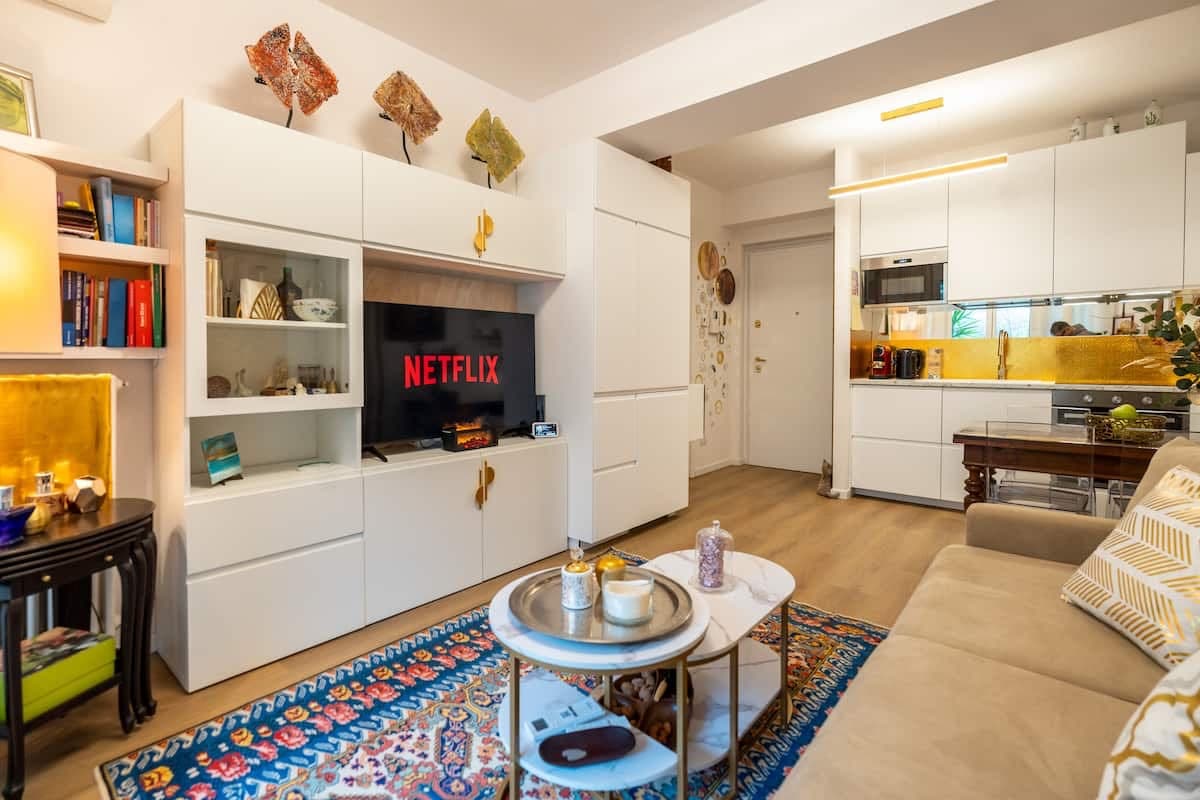 Soggiorno con libreria e cucina sullo sfondo