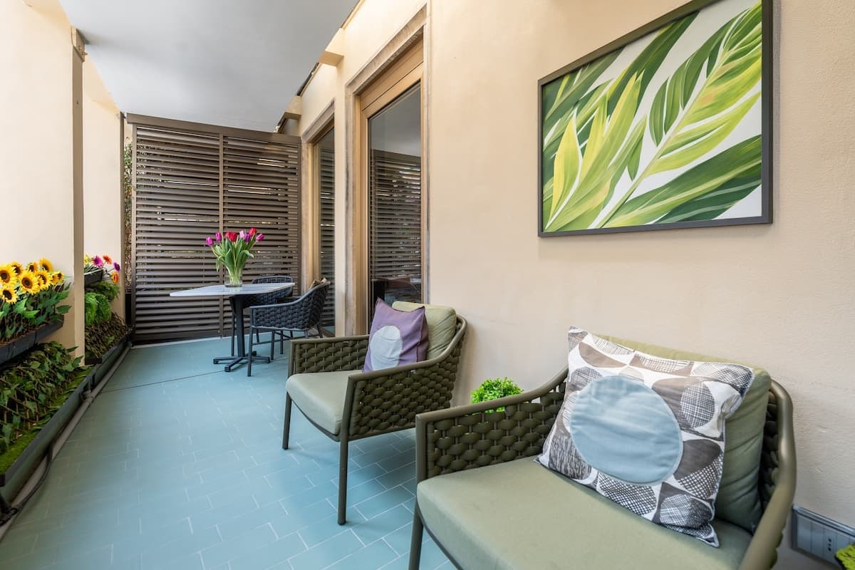 Terrazzo arredato con fioriere, divanetto e tavolino