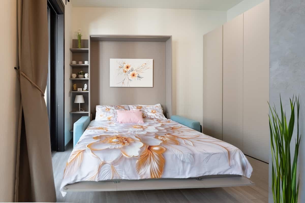 Letto con biancheria a fiori e mensole a giorno