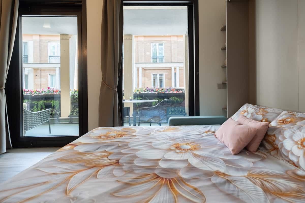 Letto con vista sul terrazzo attraverso la portafinestra